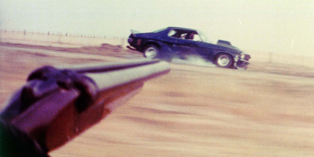 Aiming the shotgun at Nightriders HQ Monaro in Mad Max
